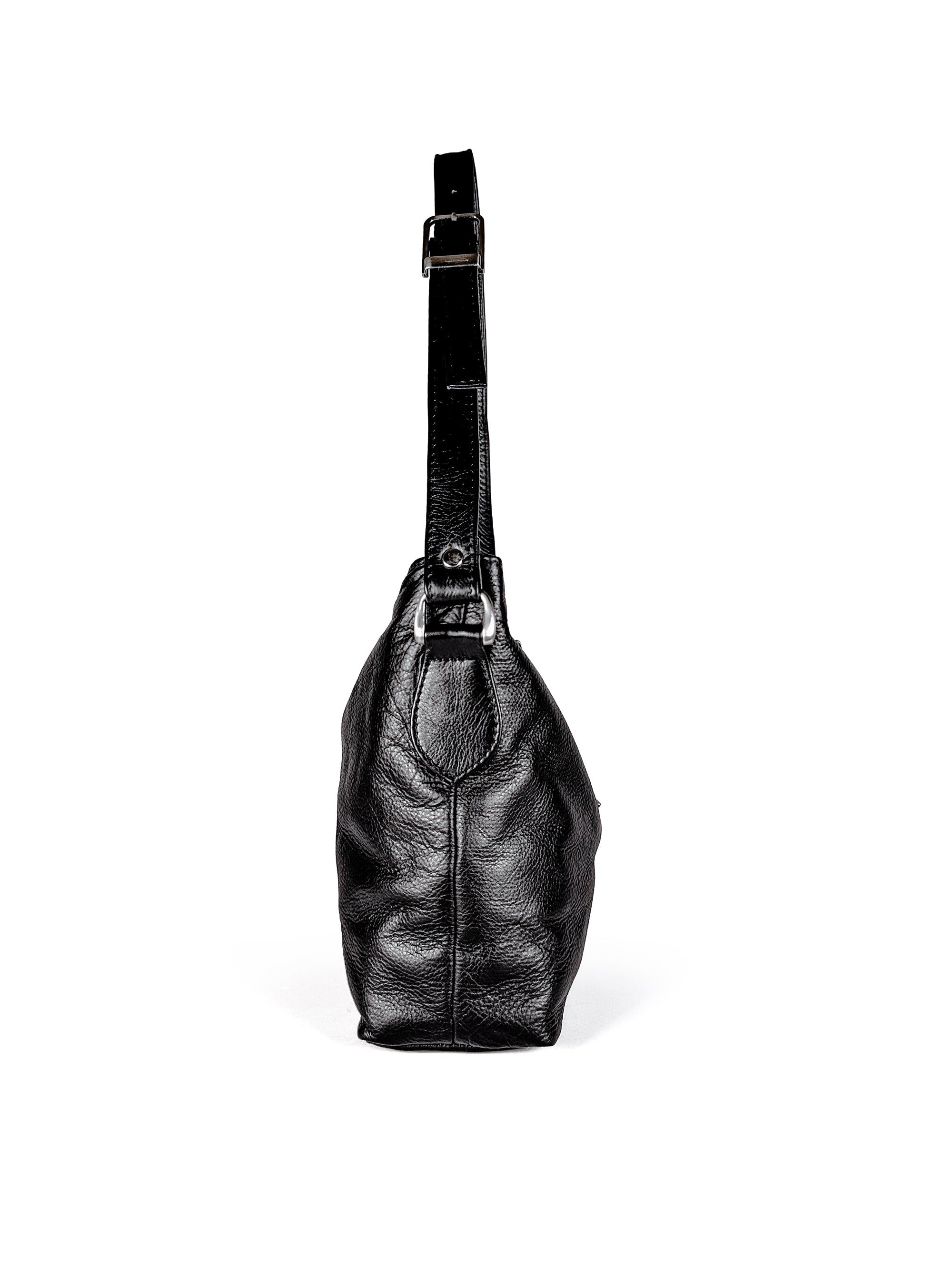 Side view of black leather handbag with a strap with a brushed nickel buckle and d-ring on a white background