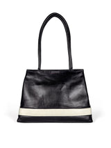 Black leather medium sized handbag, with tapered top. Inlaid white leather accent stripe on front panel. Magnet depth expansion. Chic padded pipe shoulder straps. Upcycled, circular, sustainable. Front view.