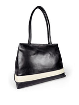 Black leather medium sized handbag, with tapered top. Inlaid white leather accent stripe on front panel. Magnet depth expansion. Chic padded pipe shoulder straps. Upcycled, circular, sustainable. 3/4 view 1.