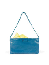 Small slim blue leather handbag. Elegant pale yellow satin lining and contrast stitch accent. Sunken zipper closure. Front view with lining showing. Upcycled, circular, sustainable.