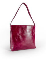 Medium polished burgundy leather handbag. Elegant muted pink satin lining. Sunken zipper closure. 3/4 view 1. Upcycled, circular, sustainable.