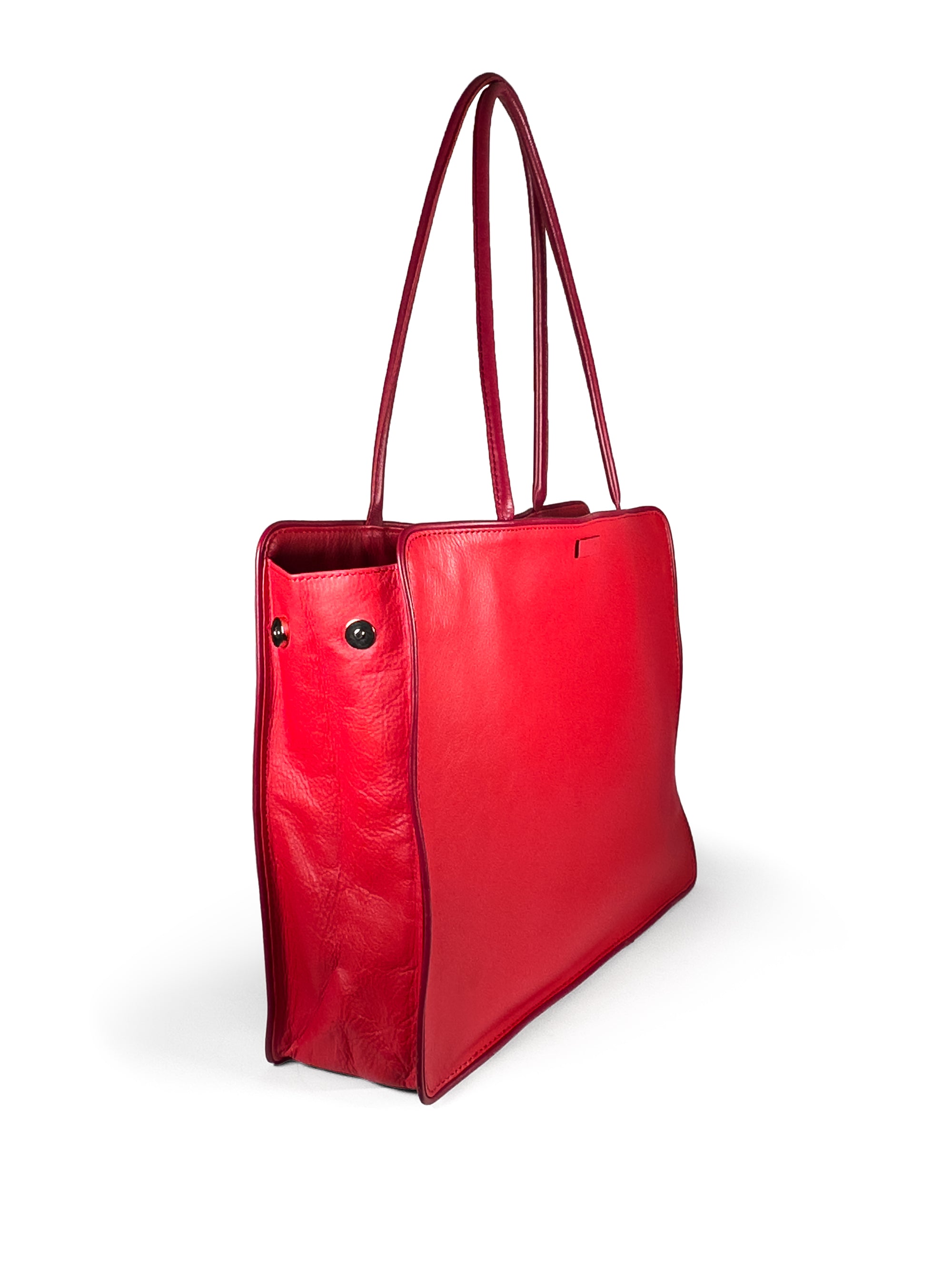 Large vivid red leather tote bag with deep red piping, xl pipe shoulder straps, lining and contrast stitches. Side panel hidden magnet expansion to 4 inches depth. 3/4 view 2 with expansion magnets open. Upcycled, circular, sustainable.
