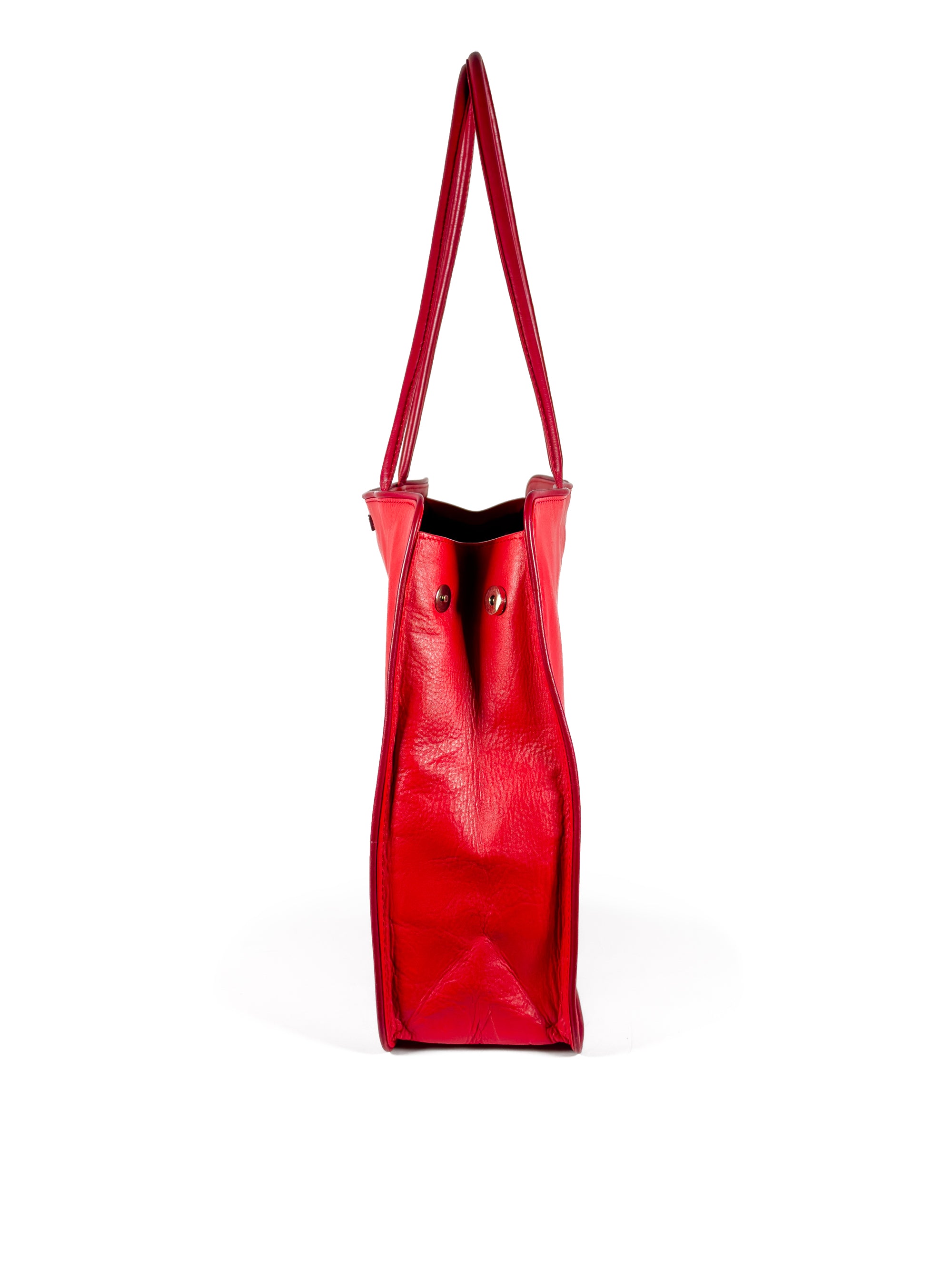 Large vivid red leather tote bag with deep red piping, xl pipe shoulder straps, lining and contrast stitches. Side panel hidden magnet expansion to 4 inches depth. Side view with expansion magnets open. Upcycled, circular, sustainable.