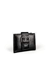 Small Wallet. Buttery pebbled black leather with nickel hardware. 1 magnet closure hidden under wide strap with buckle. 3/4 view. Upcycled, circular, sustainable.