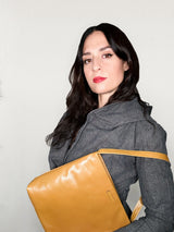 Woman holding a yellow bag against a plain background