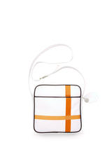 Square medium cross body bag, white coil zip closure, all white lightly distressed leather with two toned orange silkscreen off-center cross, black piping. Silver buckle on adjustable cross body strap. Upcycled, circular, sustainable. 3/4 view.