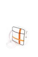 Square medium cross body bag, white coil zip closure, all white lightly distressed leather with two toned orange silkscreen off-center cross, black piping. Silver buckle on adjustable cross body strap. Upcycled, sustainable. 3/4 view.