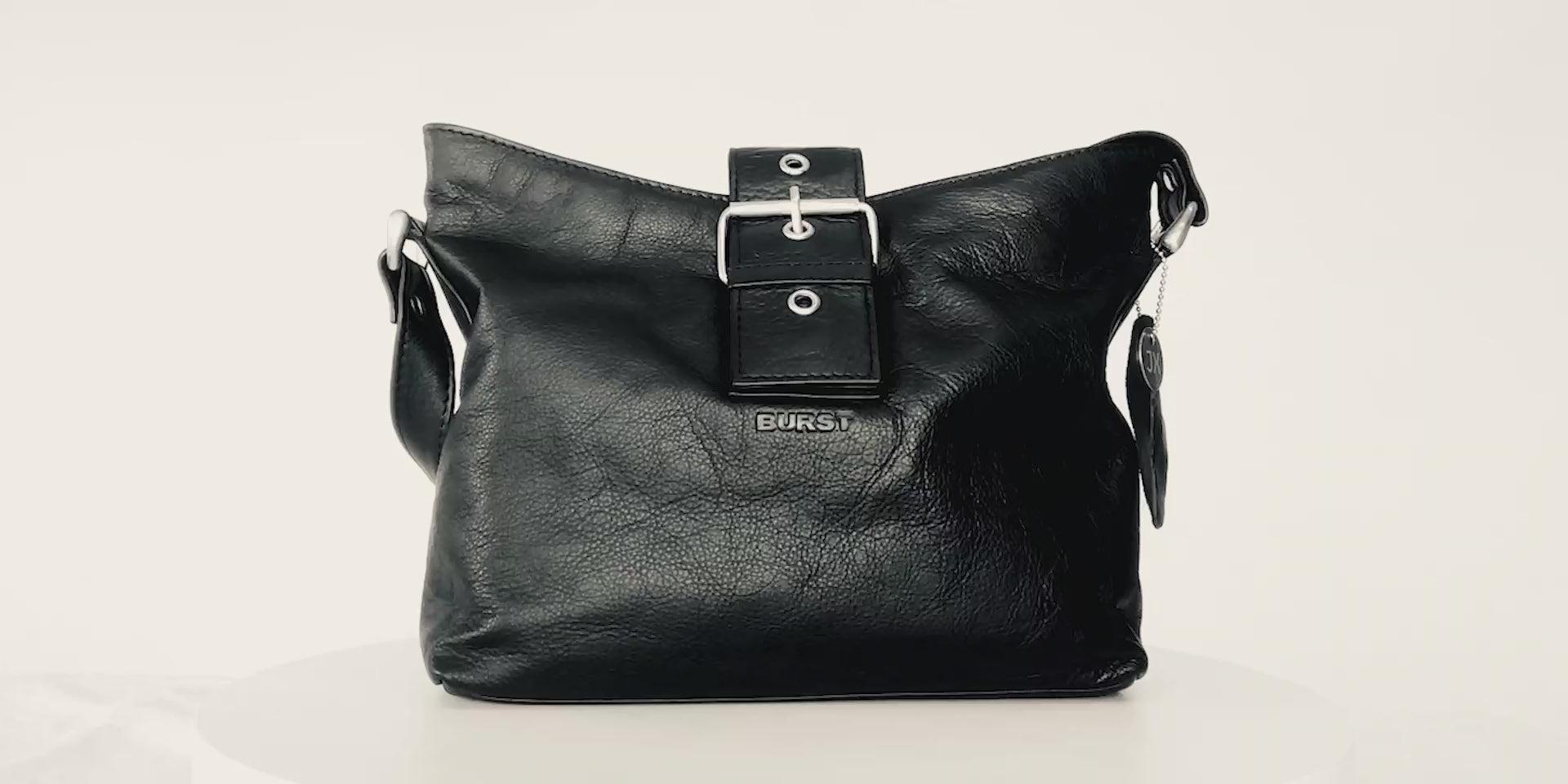 Medium handbag. Buttery pebbled black leather with nickel hardware. 1 magnet closure hidden under wide strap with buckle. 360 view. Upcycled, circular, sustainable.