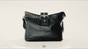 Buttery pebbled leather, 1 magnet closure hidden under wide strap with buckle. Perfect size for all day. Upcycled sustainable. Black with nickel hardware. Upcycled, sustainable.