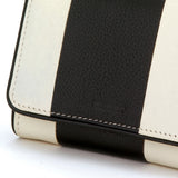 Collectors edition logo detail of medium sized cream leather wallet, with inlaid black leather stripe accent. Flap close with hidden snap.